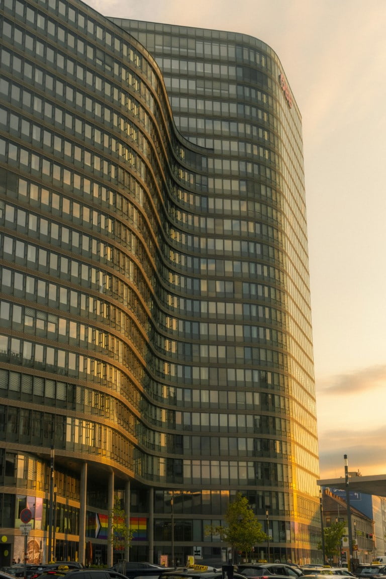 A modern building featuring numerous windows, reflecting sunlight and showcasing a contemporary architectural design.